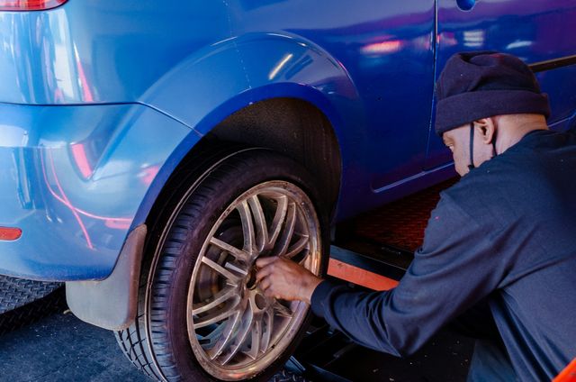 Een mecanicien zet de wielbouten van een achterwiel vast